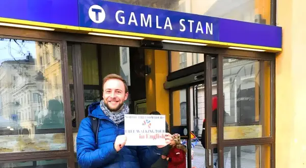 Glad guide vid Gamla Stan tunnelbanestation, redo för en guidad tur i Stockholm.