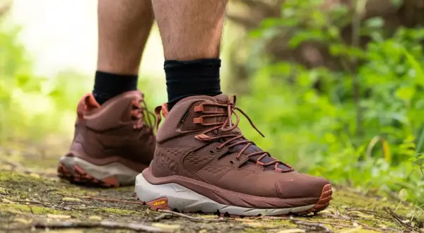 Scarpe da hiking: il loro significato è avventura e comfort su ogni sentiero. Stivali marroni su un sentiero nel bosco.
