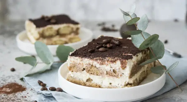 Pyszne tiramisu z serka mascarpone, udekorowane kawą i gałązką eukaliptusa. Idealny deser, gdy zastanawiasz się, co zrobić z serka mascarpone.