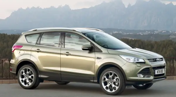 Złoty Ford Kuga 2 na tle górskiego krajobrazu.