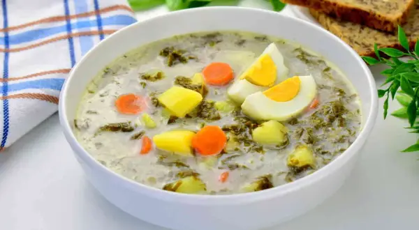 Zupa szczawiowa tradycyjna z ziemniakami, marchewką i jajkiem. Pyszne danie na wiosnę.
