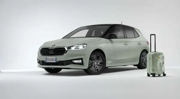 La Skoda Fabia 2026, color verde pastello con tetto nero, è pronta per un viaggio. Accanto, una valigia verde con la scritta "Find your way".