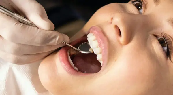 Dentysta bada zęby pacjentki, przygotowując się do zabiegu gingiwektomii.