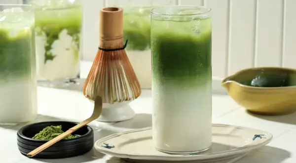 Zielony napój z lodem i mlekiem, proszek matcha, bambusowa miotełka. Czy matcha jest zdrowa? Tak, to napój pełen antyoksydantów.