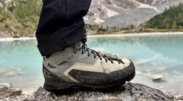 Buty Garmont Vetta GTX na kamieniu, z widokiem na turkusowe jezioro i góry. Gotowe na każdą wyprawę.