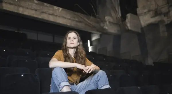 Federica Rosellini seduta tra le file vuote di un cinema, con uno sguardo pensieroso.