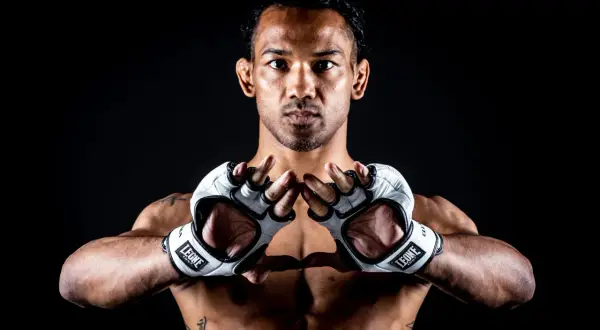 Benson Henderson, en fighter redo för strid, med vita handskar och intensiv blick.