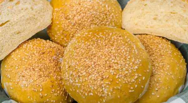 Koszyk pełen puszystych bułek bez drożdży, posypanych sezamem. Idealne na kanapki i burgery.