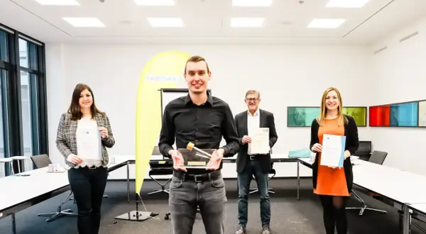 Glückliche Absolventen mit Urkunden und Pokal. Gute Aussichten für die Elektroniker Ausbildung Gehalt Bayern.