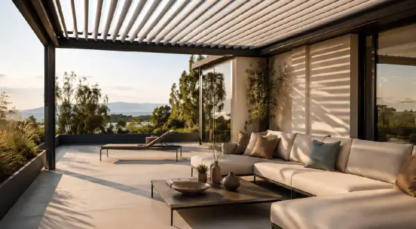 Terrazza con divano e lettino, sotto una pergola con lamelle orientabili, ideali come sistemi oscuranti esterni per finestre, con vista sul mare.