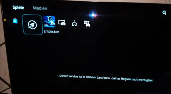 PS5-Menü mit "Spiele" und "Medien". "Entdecken" ist ausgewählt. Eine Meldung besagt: "Dieser Service ist in deinem Land bzw. deiner Region nicht verfügbar.