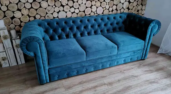Elegancka kanapa chesterfield w kolorze turkusowym, idealna do salonu. To przykład wysokiej jakości produkcji mebli tapicerowanych.