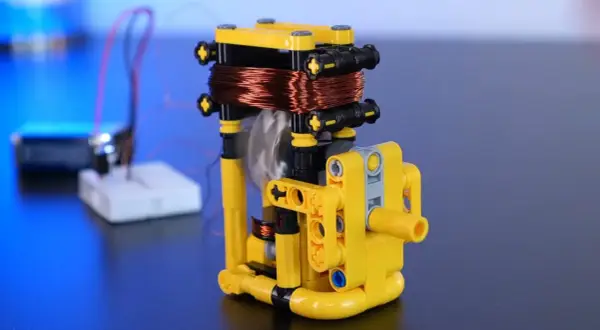 Model z klocków pokazuje, jak wytworzyć prąd z magnesu. Wirująca cewka miedziana nad magnesem generuje energię.