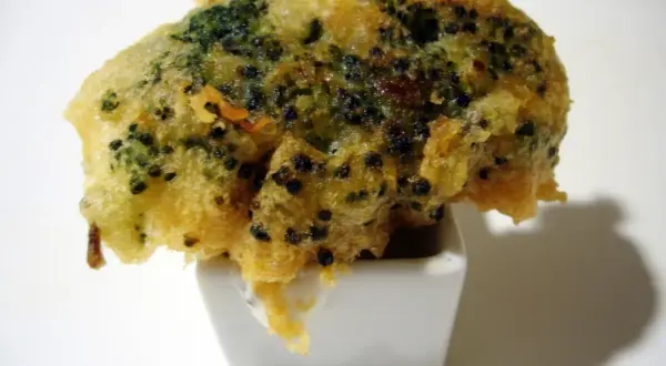 Brocoli en tempura crujiente, servido en un pequeño cuenco blanco con salsa.