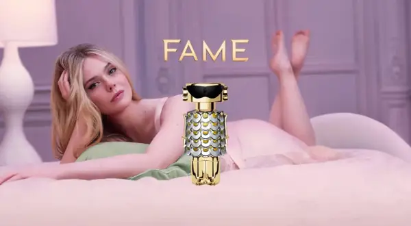 Elle Fanning w łóżku z flakonem perfum FAME Paco Rabanne.