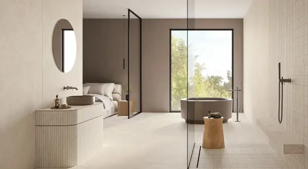 Élégante salle de bain beige et noir avec baignoire, douche, lavabo et lit. Un espace moderne et épuré.