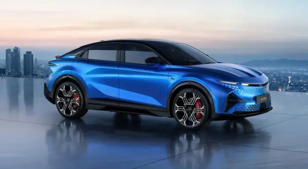 Alpine A390 blu elettrico, un'auto sportiva futuristica con un design aerodinamico, si staglia contro uno skyline cittadino al tramonto.