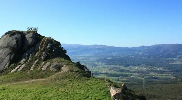 Ascenso al Pico da Frouxeira, con escaleras de madera y vistas panorámicas de valles verdes y montañas.