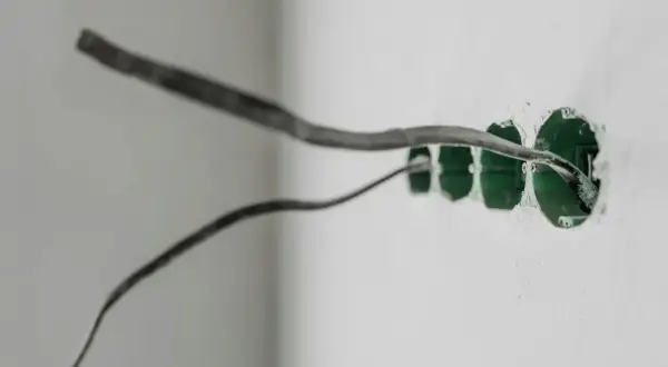 Przewody elektryczne wchodzą do zielonych puszek podtynkowe. Wkrótce będzie gotowe uziemienie w gniazdku.