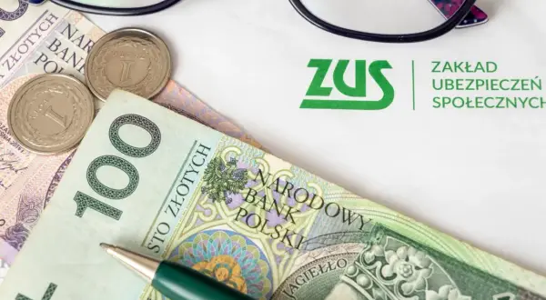 ZUS i pieniądze, by dowiedzieć się, ile wynosi renta po zmarłym ojcu. Okulary i długopis sugerują analizę dokumentów.