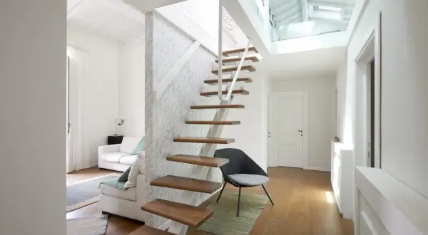 Scala interna moderna in legno e metallo, con design a sbalzo. La normativa scale interne uso privato è rispettata, garantendo sicurezza e stile.