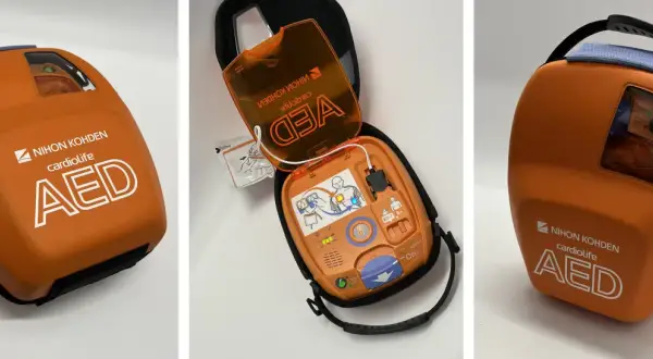 Pomarańczowy defibrylator AED Nihon Kohden Cardiolife w etui, otwarty i zamknięty.