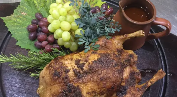 Gefüllte Ente mit Trauben und Rosmarin, serviert mit einer Sauce. Ein Festmahl, das an Schlehen Rezepte erinnert.