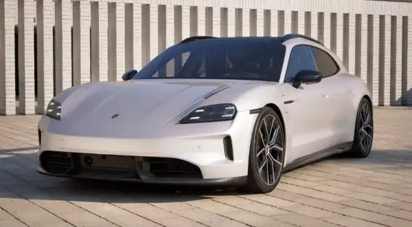 Biały Porsche Taycan Cross Turismo na tle nowoczesnej architektury. Sprawdź, jaka jest porsche taycan cena.