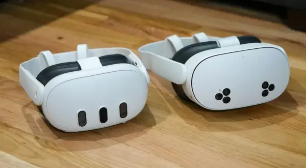 Dwa białe gogle VR Meta Quest 3 na drewnianym blacie.