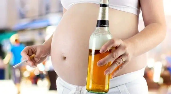 Ciężarna kobieta trzyma papierosa i piwo. To obraz dorosłego dziecka alkoholika w związku, które powiela schematy.