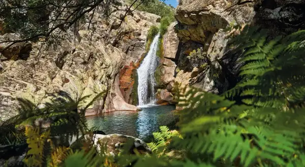 Cascada en un entorno rocoso y frondoso. Un lugar idílico que ver en Cáceres provincia para disfrutar de la naturaleza.