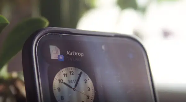 Szybki udostępnianie wideo przez AirDrop. Na ekranie telefonu widoczny jest zegar.