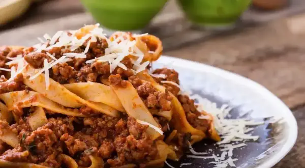 Pappardelle z bogatym sosem mięsnym, posypane parmezanem. Idealne pytanie: jakie mięso do spaghetti? Odpowiedź: mielone, duszone w sosie pomidorowym!