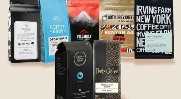 En samling påsar med koffeinfritt kaffe, inklusive märken som Lifeboost, Coffee Bros, Volcanica, Out of the Grey, Irving Farm, Kicking Horse och Peet's Coffee.