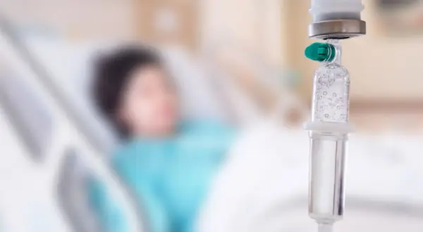 Pacjent w łóżku szpitalnym, kroplówka w zbliżeniu. Trudno określić, który dzień po chemioterapii jest najgorszy.
