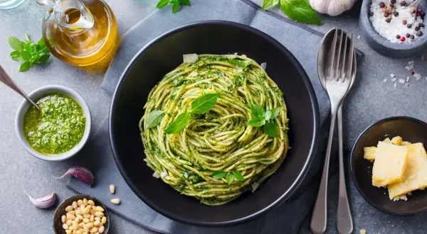 Sycący obiad bez mięsa: spaghetti z pesto, świeżą bazylią, orzeszkami pinii i parmezanem. Idealne danie dla wegetarian.