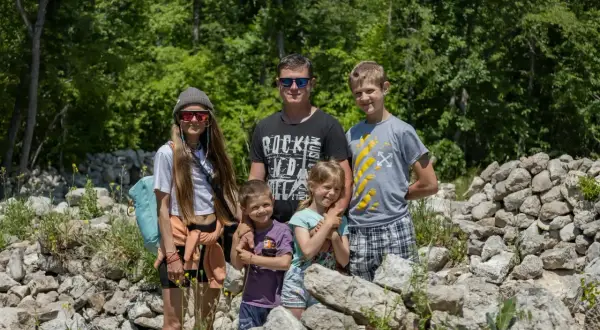 Rodzina odkrywa czeskie atrakcje dla dzieci wśród kamiennych ruin i zieleni. Radosne twarze dzieci i rodziców.