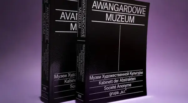 Dwie czarne książki z białymi napisami: "Avant-Garde Museum" i "Awangardowe Muzeum". W tle fioletowe.