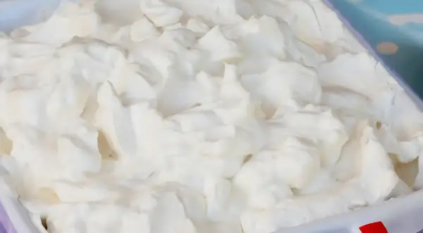 Glace italienne maison sans machine, texture aérienne et onctueuse dans un plat blanc. Parfait pour une recette facile et gourmande.