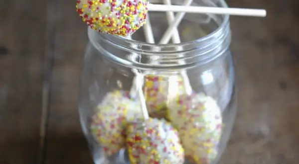 Bunte cake pops mit mascarpone, verziert mit Streuseln, stecken in einem Glas.