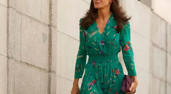 Letizia Ortiz luce un elegante vestido verde estampado con flores, portando un bolso morado.