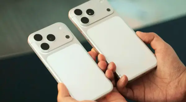 Deux iPhones blancs, prêts pour la sortie du nouvel iPhone, tenus dans des mains.