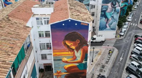 El **Soho Viertel Málaga** se llena de arte con murales gigantes. Una niña mira una estrella en un atardecer mágico.