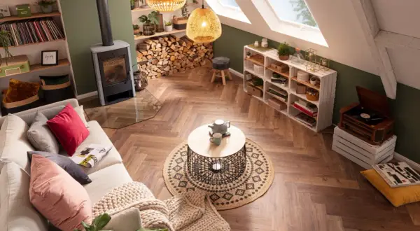 Gemütliches Wohnzimmer im Boho-Stil mit Kamin, bequemer Couch, Rattan-Lampen und vielen Pflanzen.