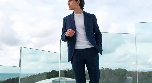 Uomo con completo a quadri blu, un perfetto pantaloni blu abbinamento uomo per un look casual chic.