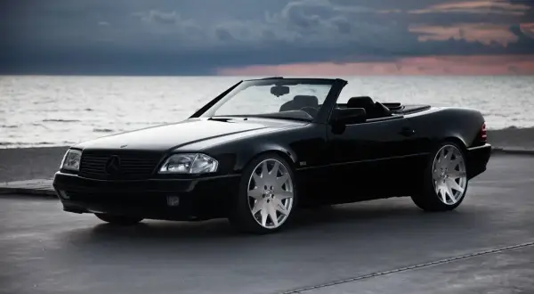Svart cabriolet vid havet, en dröm om en skattebefriad bil som väntar på en solig dag.