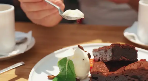 Słodki deser z brownie i lodami, serwowany w pomelo bistro. Idealny na popołudniową kawę.