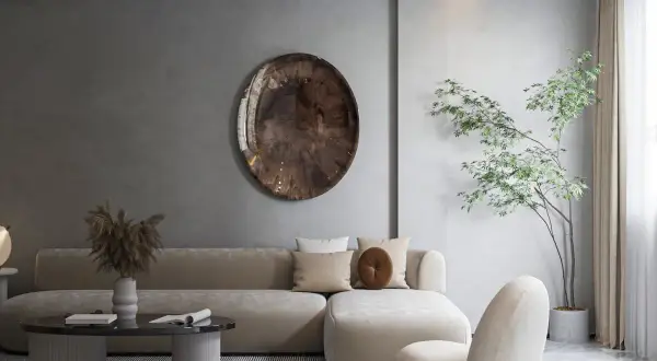 Salon w stylu japońskim skandynawskim. Jasna sofa, okrągły stolik, dekoracyjna taca na ścianie i drzewko bonsai tworzą harmonię.