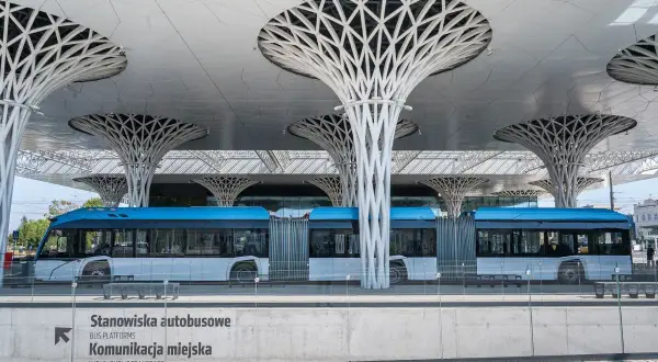Nowoczesny dworzec autobusowy w Lublinie, z niebieskim autobusem i charakterystycznymi, drzewiastymi podporami dachu. Podobne do tych w Toruniu.