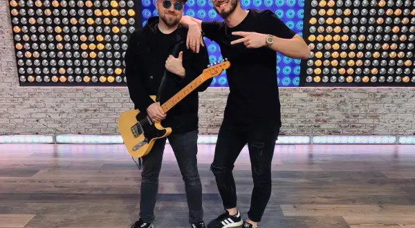 Dwóch muzyków, jeden z gitarą, gotowych do nagrania nowych łobuzy utwory.